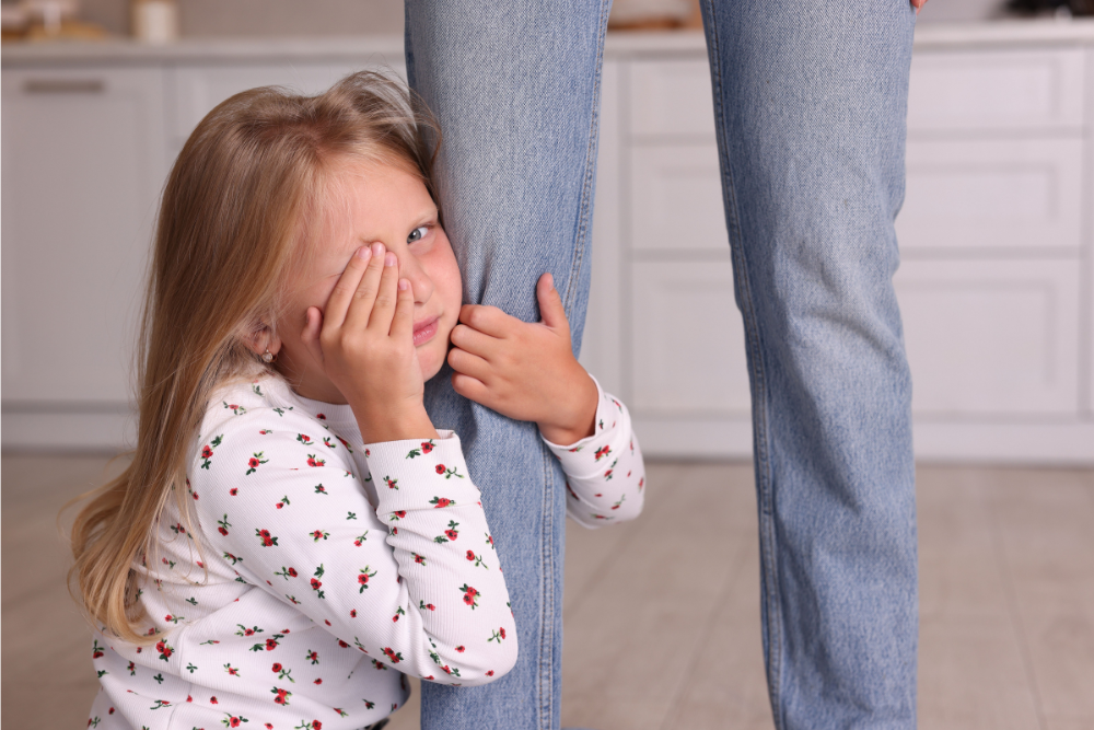 Petite fille anxieuse se cachant derrière sa maman, illustration pour la gestion de la peur chez l'enfant en sophrologie