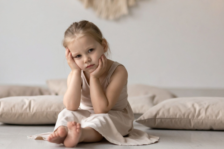 Enfant qui s'ennui assis par terre, bienfaits de l'ennui et sophrologie pour